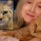Smiling woman holding orange cat in her arms